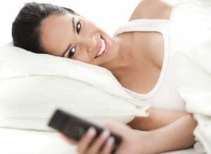 Woman looking at the mobile as she woke up